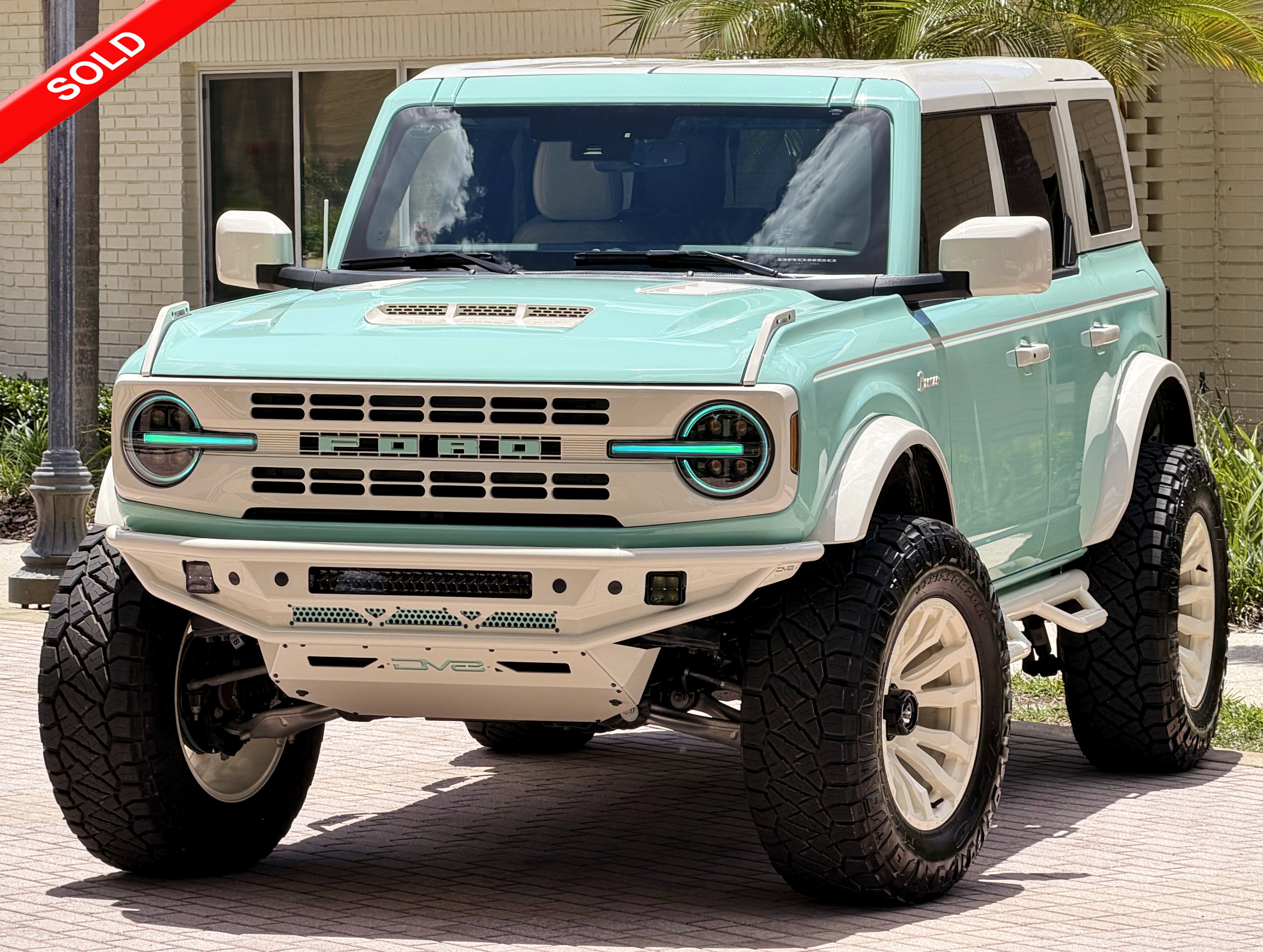 2025 Ford Bronco V6 Wimbledon White & Jade Retro Outer Banks Custom Lifted in Jade Wimblendon White — front three-quarter view